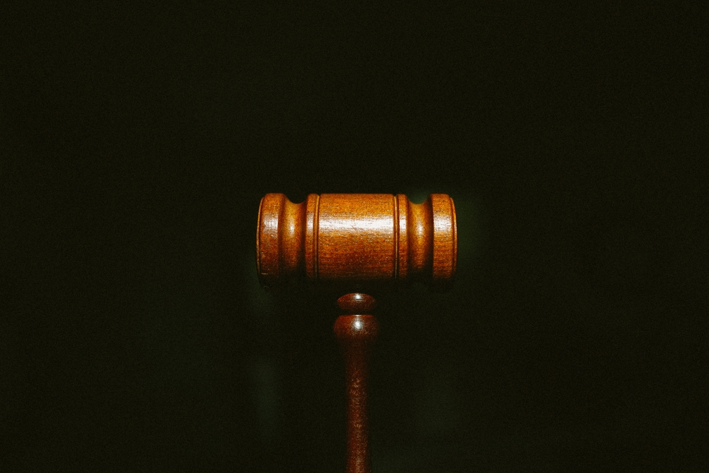 What to Do If You Are Being Sexually Harassed at Work - A wooden gavel centered on a dark background with grain.
